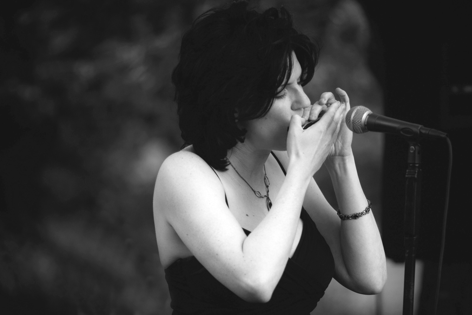 Jackie playing harmonica — black and white close-up
