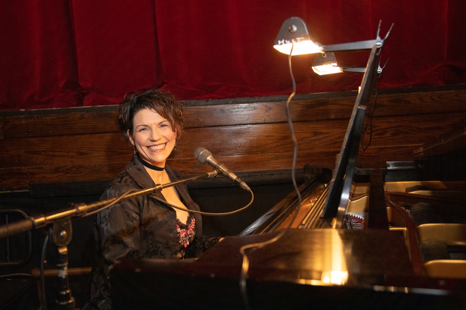 Jackie at the piano, smiling warmly